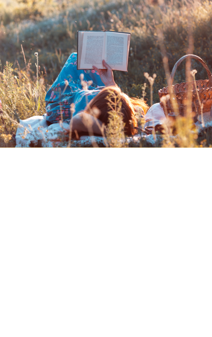 Woman reading in a field in the fall.