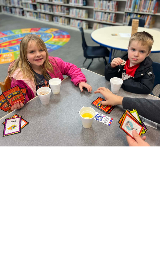 Two kids and a parent playing a card game.