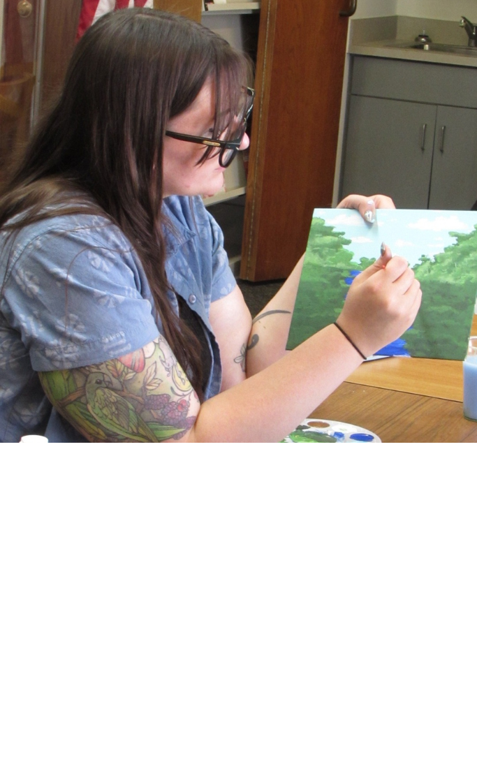 Mae painting a river scene.